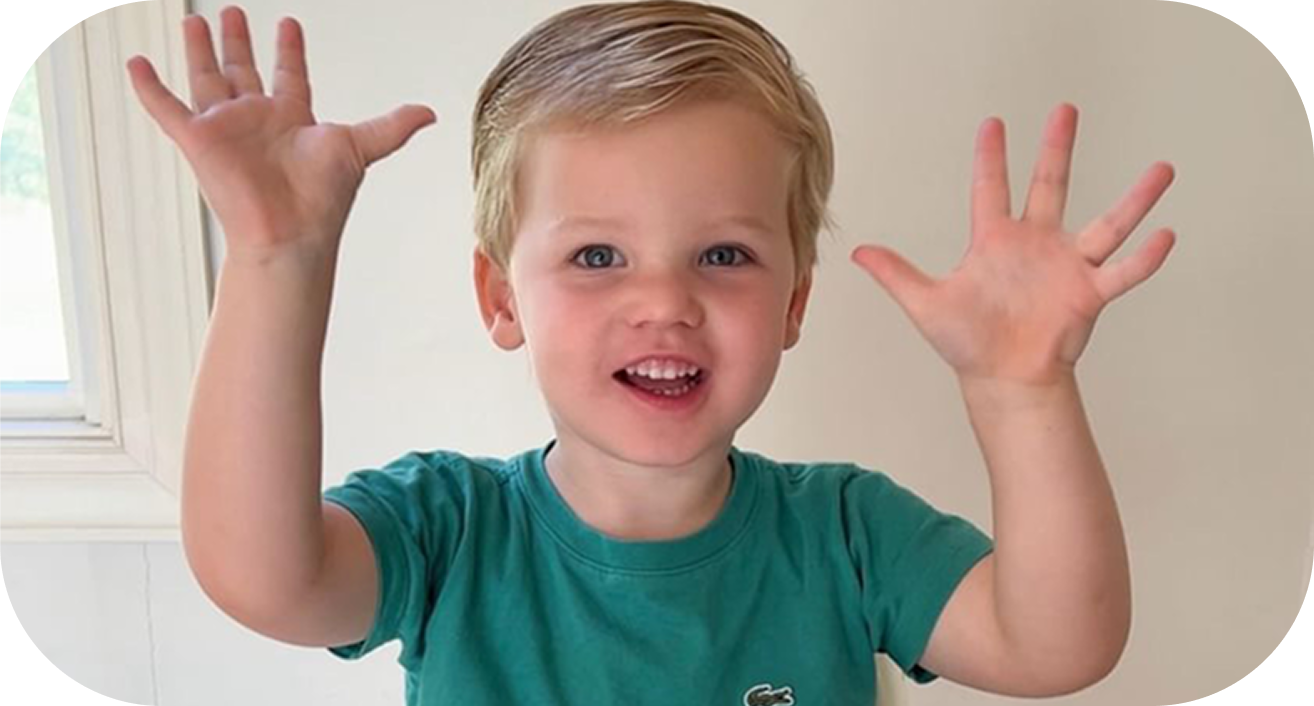 Smiling child with both hands raised